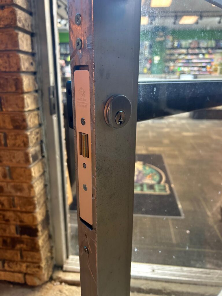 Aluminum storefront door lock installed on a commercial glass door in the Buffalo Metro area