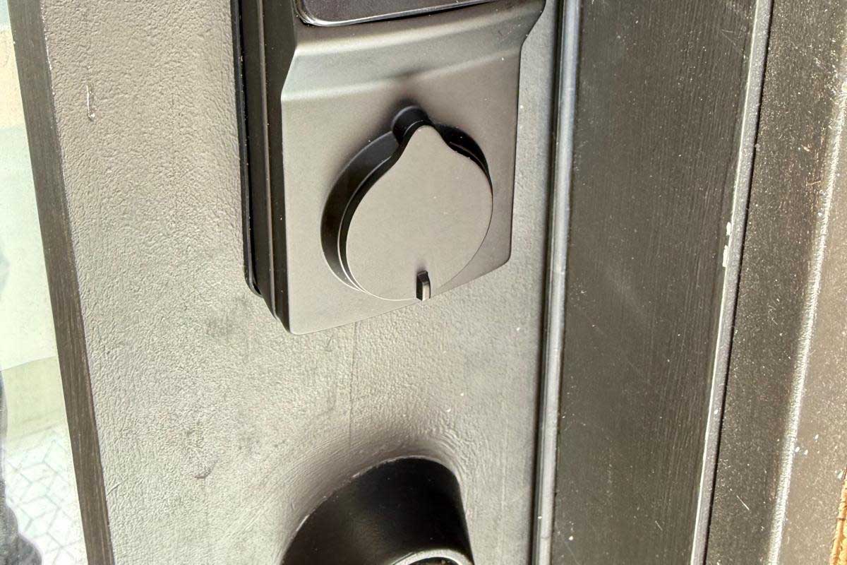 Interior thumb-turn of a black deadbolt above a matching handle set on a dark residential entry door in Buffalo, NY