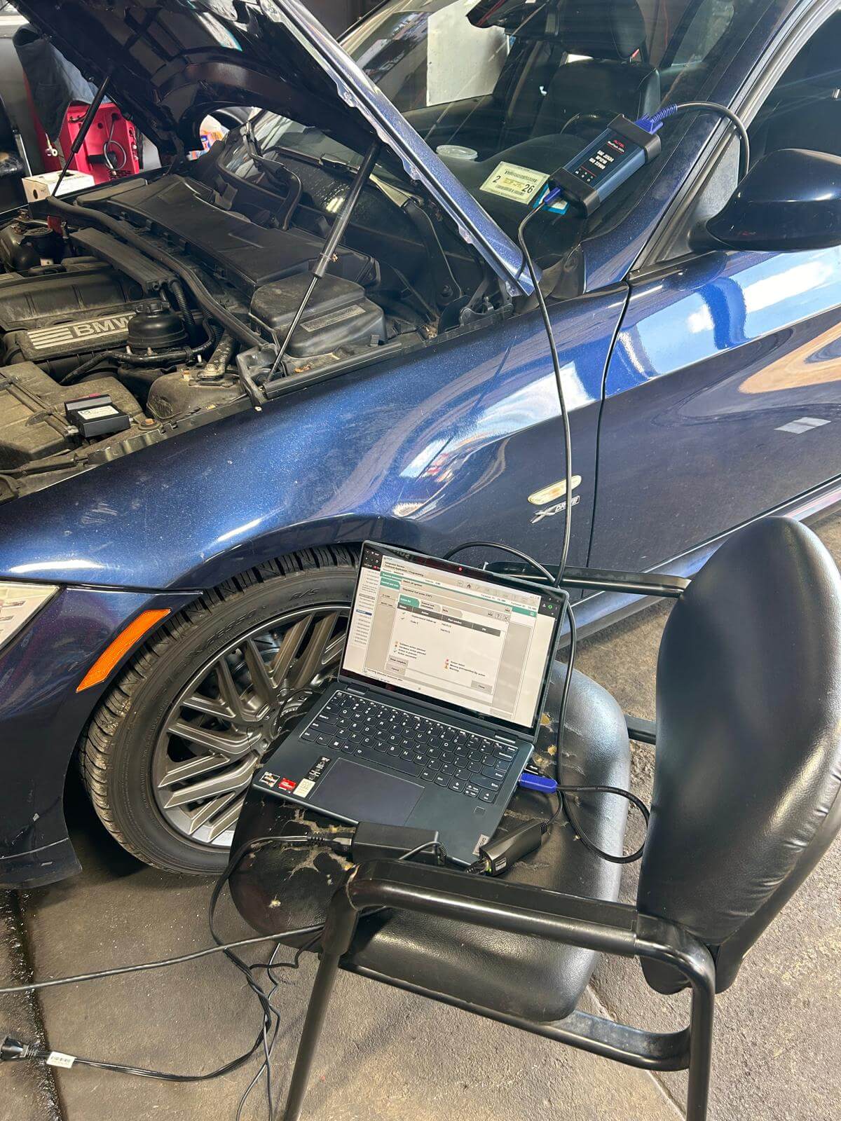 Key programming tool and laptop connected to a BMW during car computer programming in Buffalo, NY
