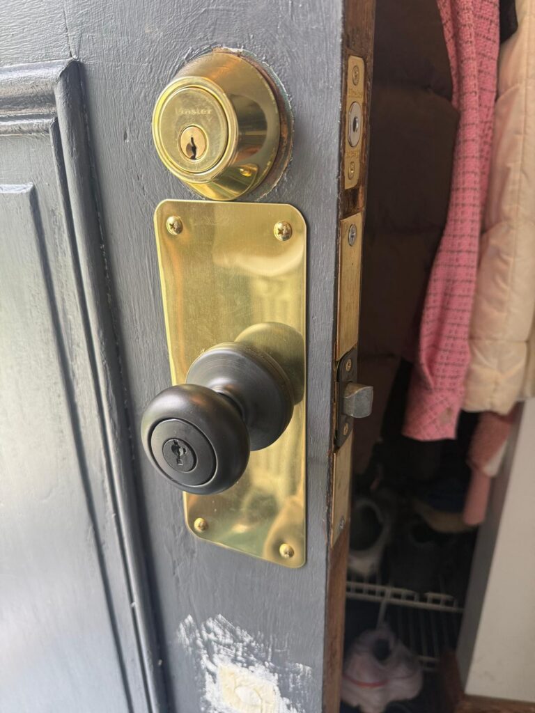 Brass deadbolt and handle set installed on a residential door in the Buffalo Metro area
