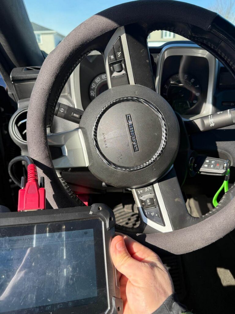 Car key programming diagnostic tool connected inside a Camaro in the Buffalo Metro area