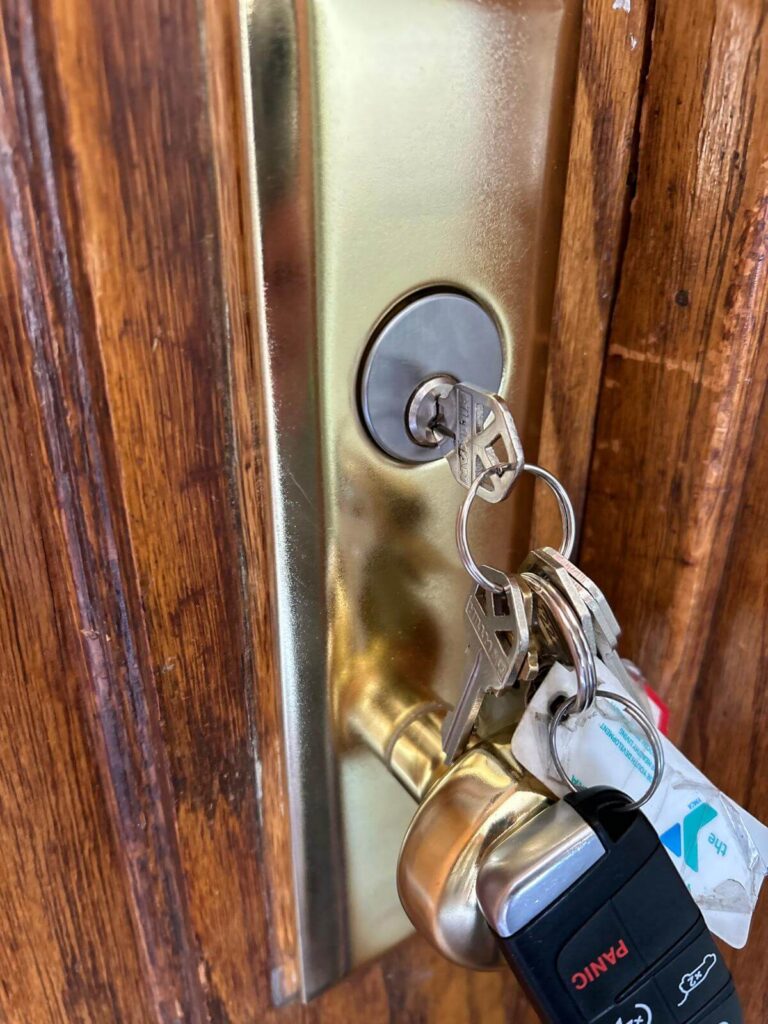 Keys and a car fob in a rekeyed lock on a wood door in Buffalo, NY
