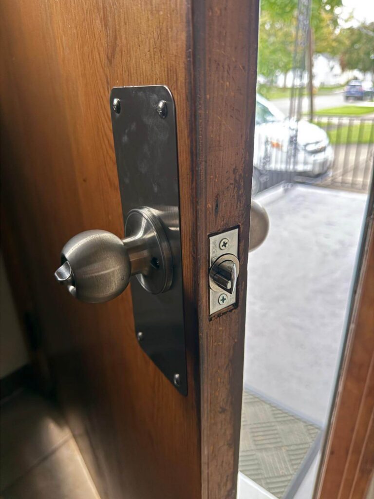 Stainless steel deadbolt and entry handle set installed on a wood exterior door in Buffalo, NY by Defense Locksmith
