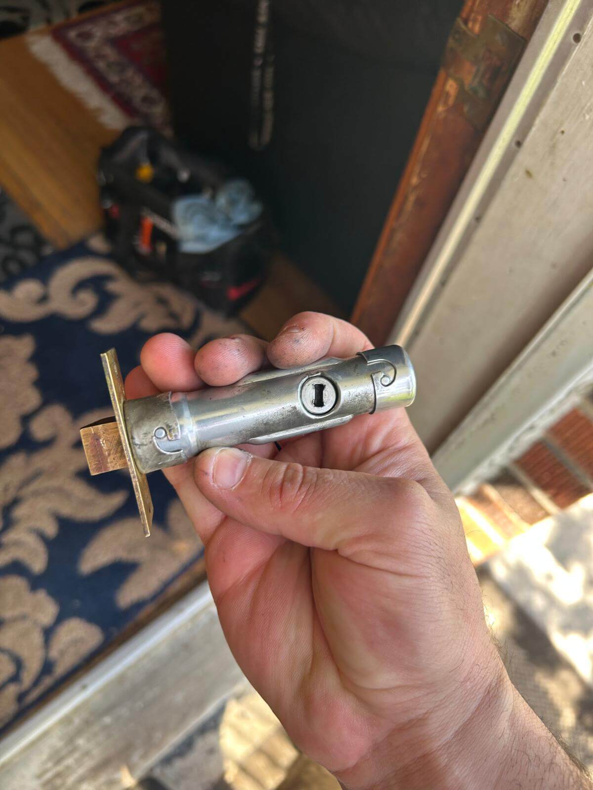 Lock cylinder rekey in Buffalo NY Defense Locksmith technician holding a door lock cylinder pulled for rekeying in Buffalo NY