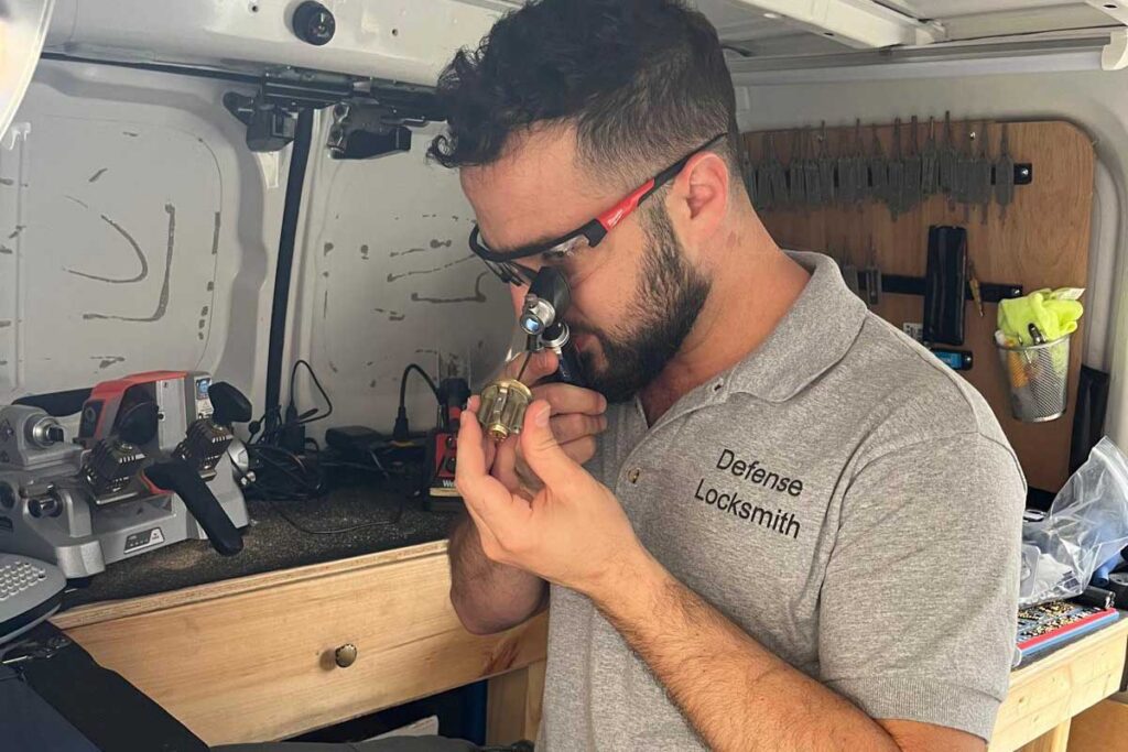 Locksmith inspecting keys with a magnifier during a job