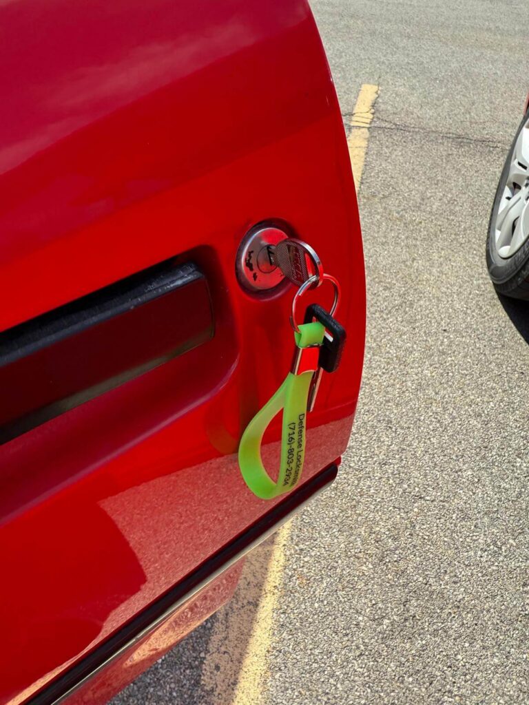 Metal car key in a red vehicle door lock in the Buffalo Metro area