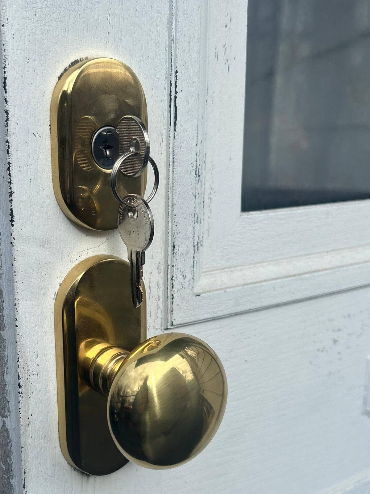 Residential deadbolt and knob lock in Buffalo, NY Brass deadbolt and knob lock on a white entry door with the key in the cylinder