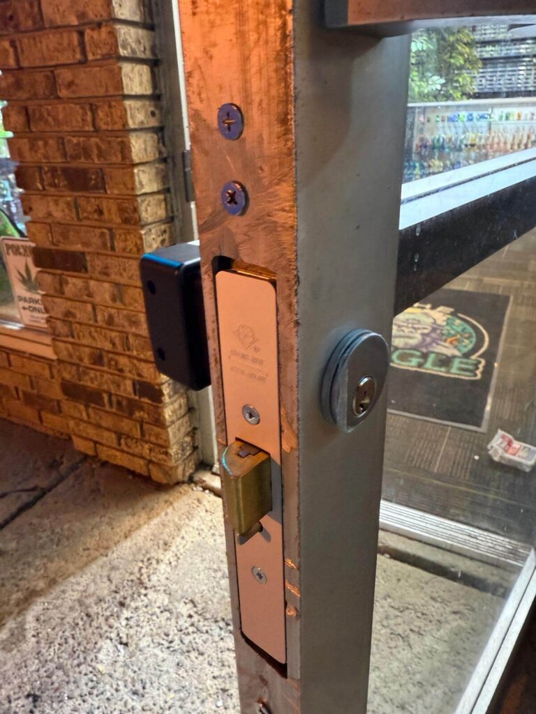 Storefront mortise lock and deadbolt installed on a commercial wood-frame glass door in Buffalo, NY