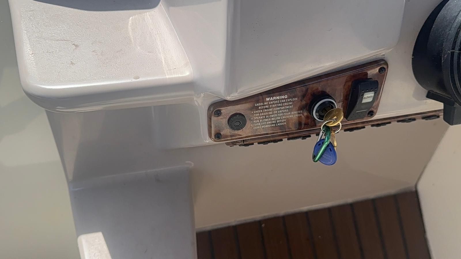 Boat ignition key cutting in Buffalo, NY Freshly cut brass boat ignition key inserted in a boat helm switch next to the blower switch