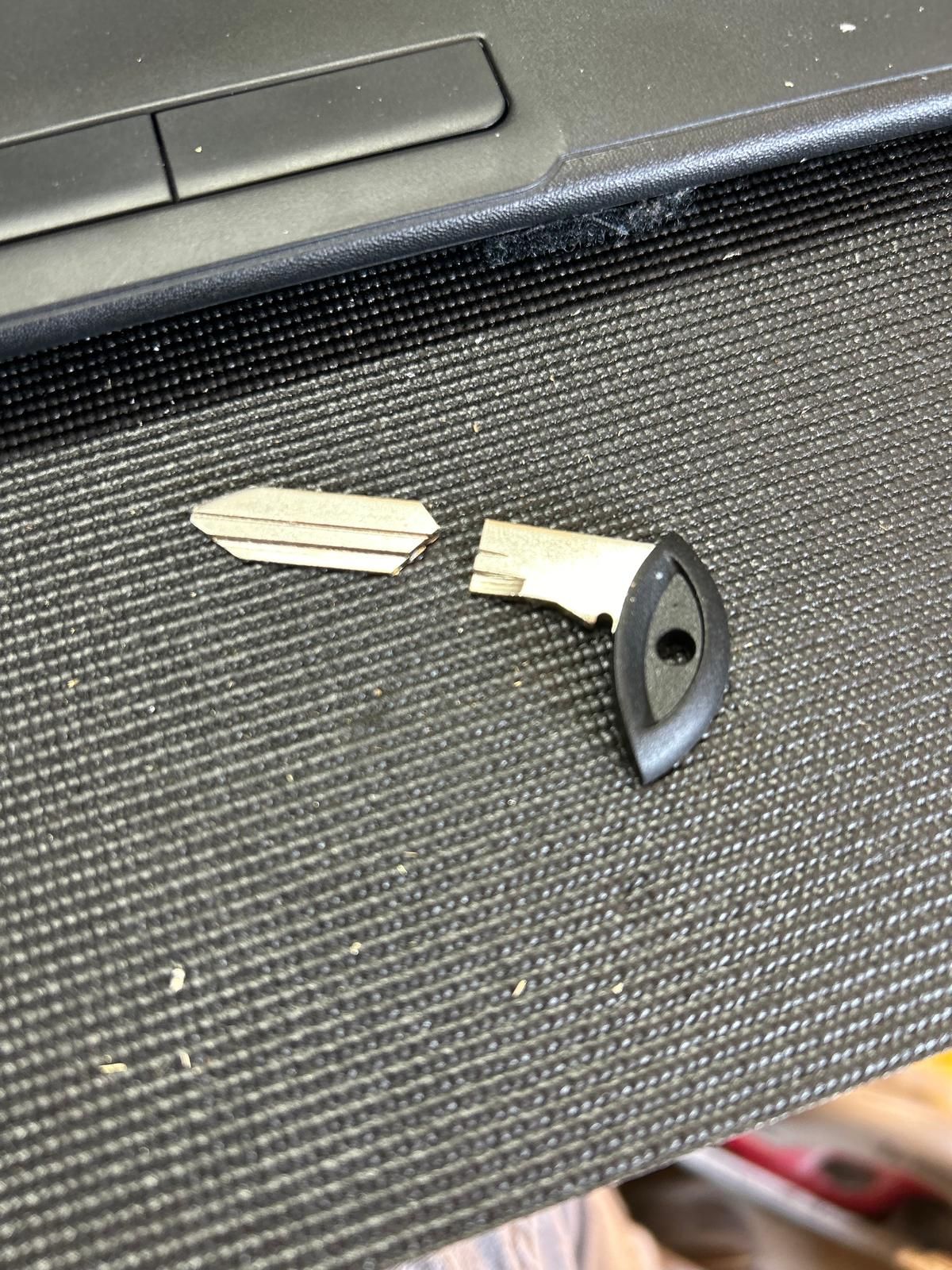 Broken car key blade replacement in Buffalo, NY A car key with its metal blade snapped into two pieces on a car interior panel