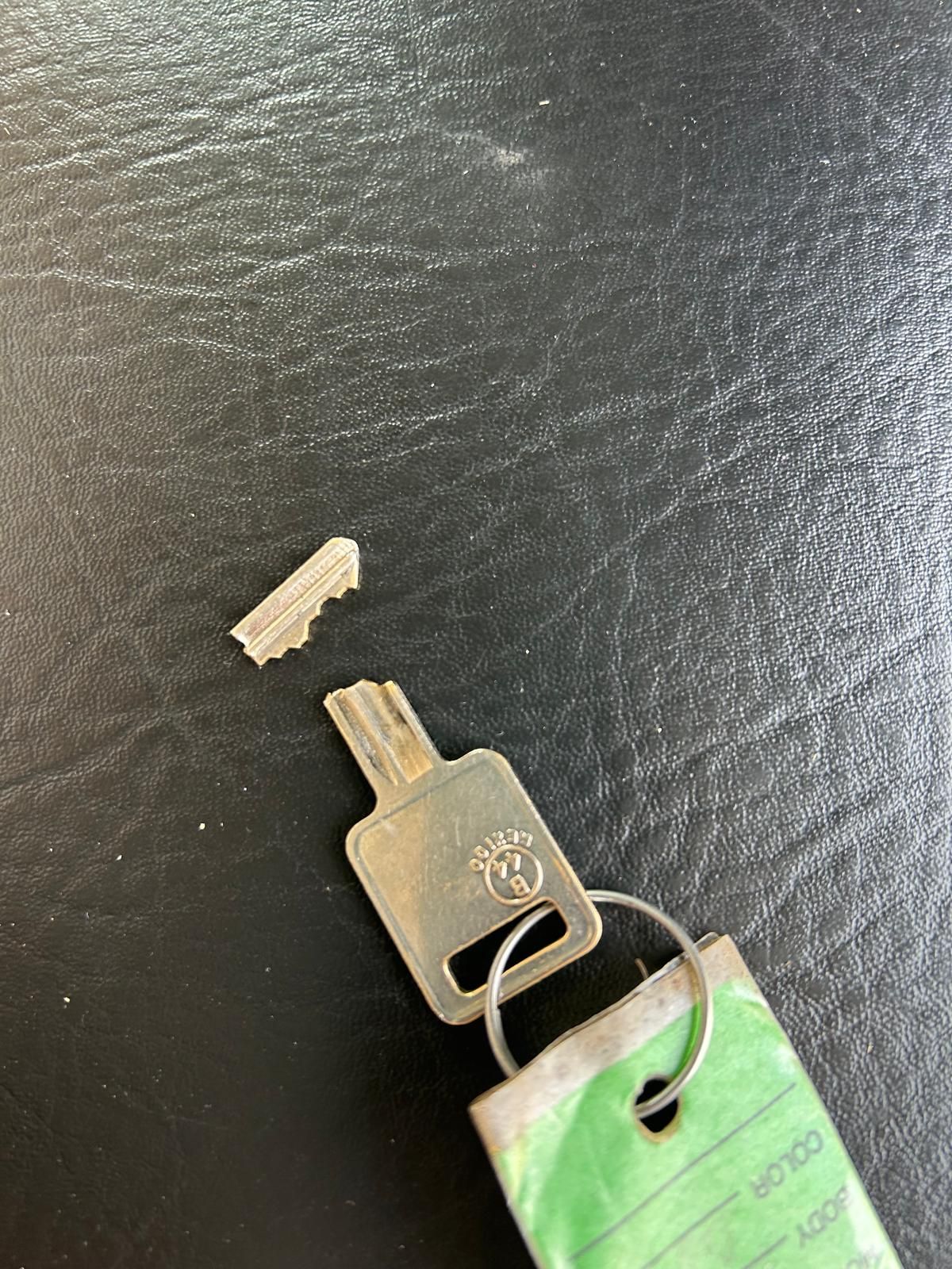 Broken house key copied from two pieces in Buffalo, NY A house key broken into two pieces on a dark surface next to a hardware key tag
