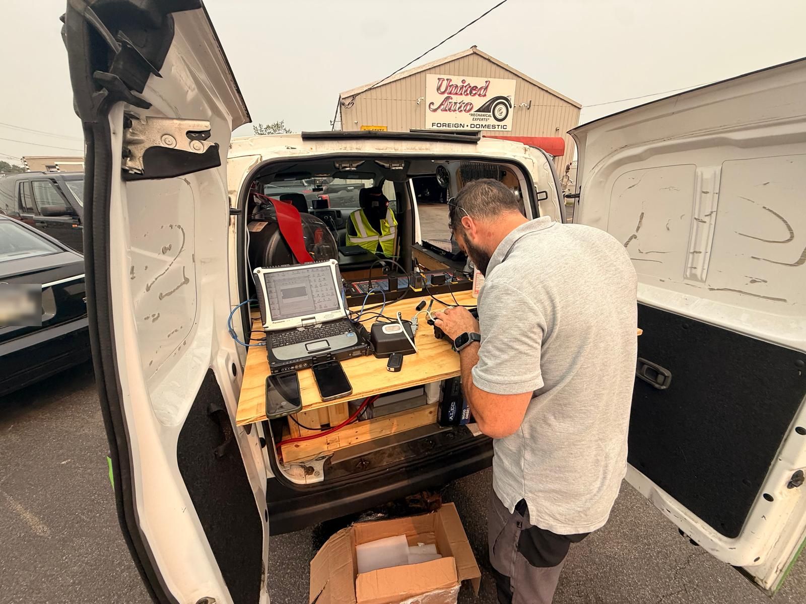Mobile key programming laptop and bench setup, Buffalo NY Rugged Panasonic laptop and key programming interface set up on a bench in a mobile locksmith van at an auto shop