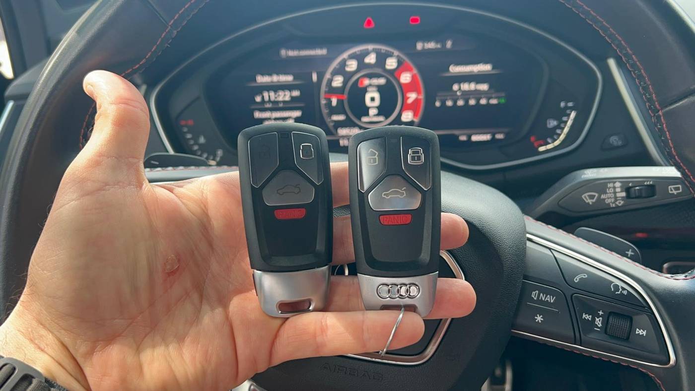 Audi SQ5 MLB key fob programming in Buffalo, NY Two Audi SQ5 smart key fobs held in front of the instrument cluster after MLB platform programming
