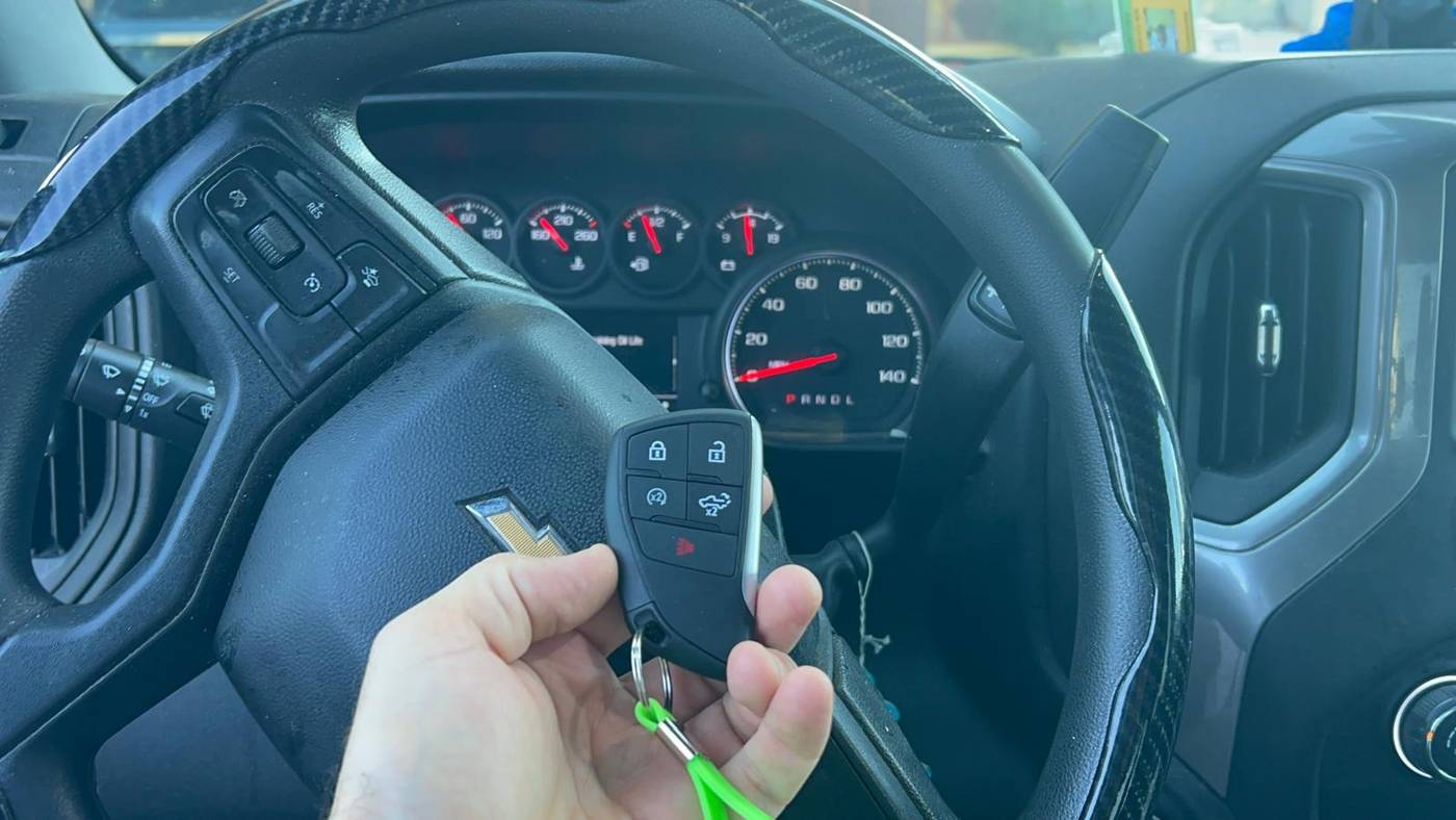 Chevrolet Silverado key fob programmed in Buffalo, NY Programmed Chevrolet Silverado key fob with a green Defense Locksmith tag in front of the gauge cluster