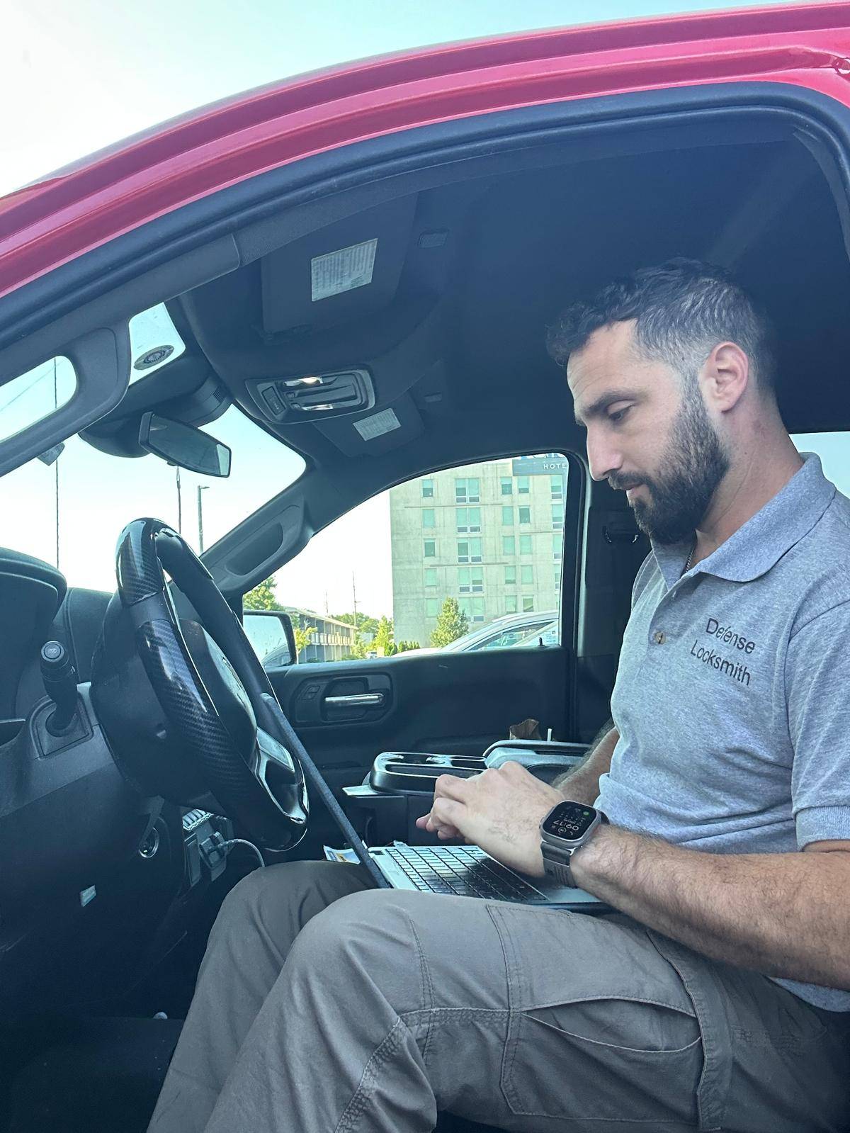 Chevrolet Silverado key programming on-site in Buffalo, NY Defense Locksmith technician programming a key with a laptop inside a 2022 Chevrolet Silverado